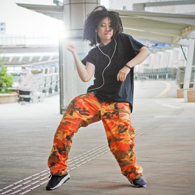 Woman dancing outside while listening to music for stress relief