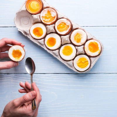 boiled eggs in hands on a wooden background