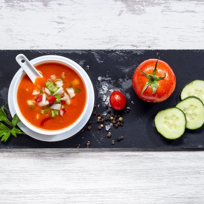 Gazpacho. Traditional Spanish tomato soup with fresh tomatoes, fresh cucumber, on white wood base. Top view