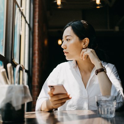 Young woman enjoying the warmth of sunlight and having a relaxing time in cafe