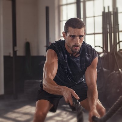 Man doing cross training exercise with rope