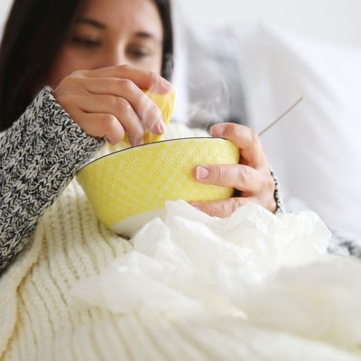 Sick woman drinking soup because soup for sore throat is good