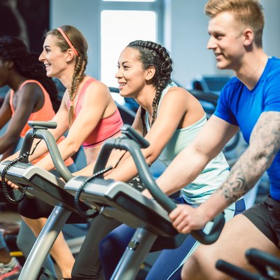 Group of people doing a HIIT cycling workout to get the benefits of HIIT