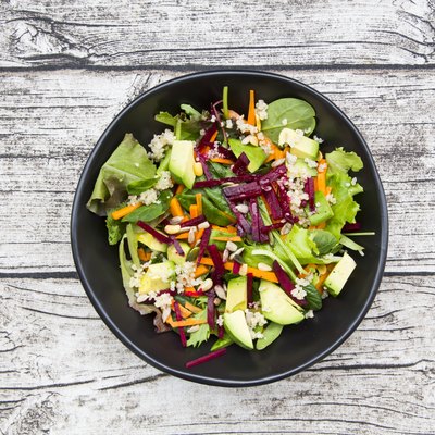 Bowl of autumnal salad with lettuce, carrots, avocado, beetroot, pumpkin and sunflower seeds, pomegranate and quinoa