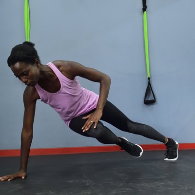 Woman practicing in a gym doing a side plank