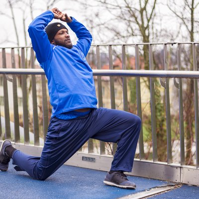 Runner doing a hip stretch outside
