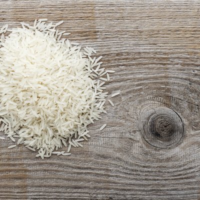 uncooked long grain rice on a wooden background.