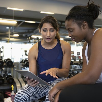 Personal trainer with tablet sharing beginner workout advice with her client