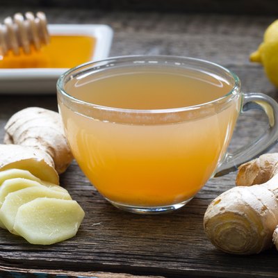 Ginger homemade tea infusion on wooden board with lemon