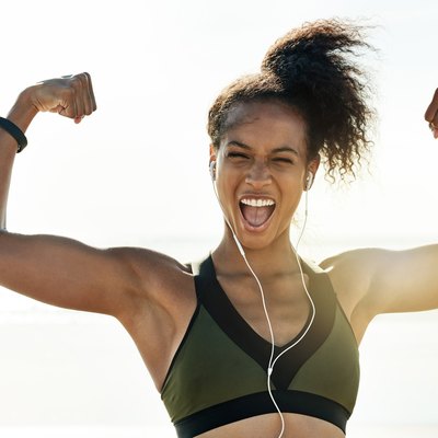 Runner flexing after her training workout on the beach