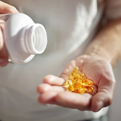 A man pouring a bottle of vitamin d supplements into his hand