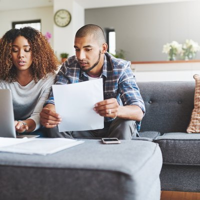 a couple looking worried as they pay bills