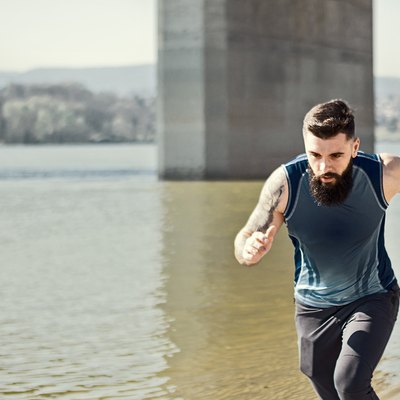 man running outdoors along a river in a virtual race