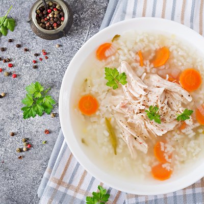 Dietary chicken soup with rice and carrots. Healthy food. Flat lay. Top view