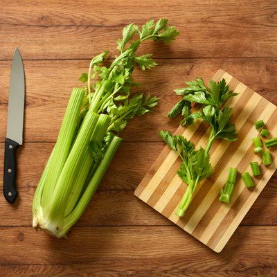 Celery cut with knife and chopping board
