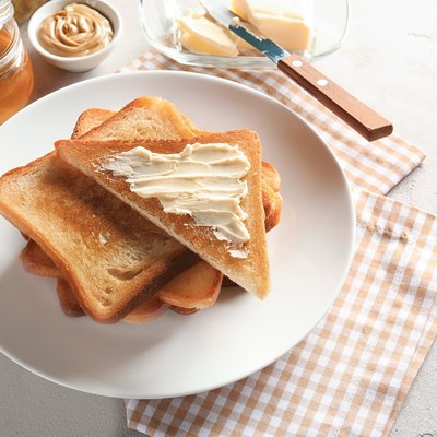 Plate with toasted bread and butter on table