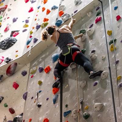 Woman climbing an indoor rock climbing wall