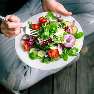 Fresh salad in hands view from above
