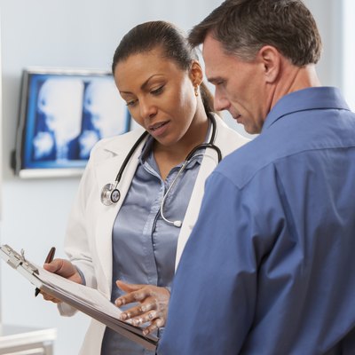 A female doctor showing a normal cholesterol levels by age chart to a male patient