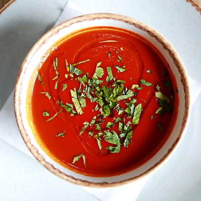 Tomato and basil soup on a white plate compatible with low-carb diet