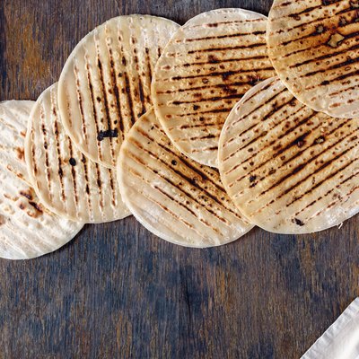 Set of tortillas cooked on a grill on a wooden table