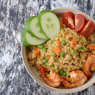 Nasi Goreng Udang. Indonesian fried rice with prawns, egg, pea, carrot, tomato and cucumber