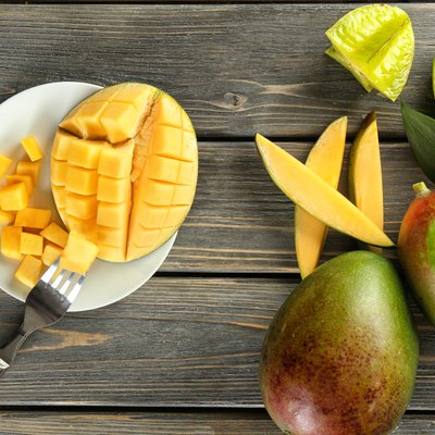 Composition with fresh mango on wooden background