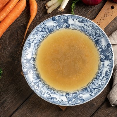 Chicken bone broth in a blue vintage plate