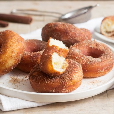 Homemade donuts with sugar and cinnamon on a wooden background. Rustic style.