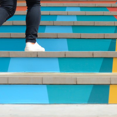 Lower part of teenage girl in casual shoe walking up outdoor colorful stair,teenage lifestyle successful concept