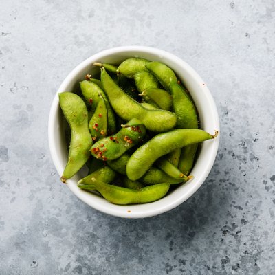 Fresh steamed Edamame soybean pod with spice on concrete background