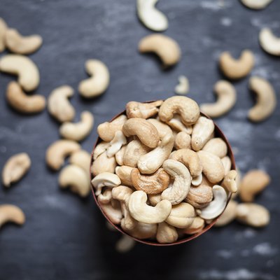 Bowl of roasted and salted cashew nuts on slate