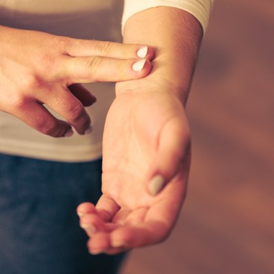Woman checking pulse on wrist closeup
