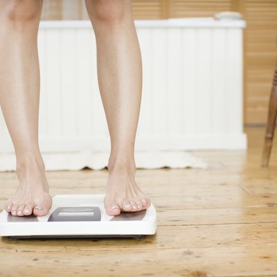 Woman weighing herself on a bathroom scale