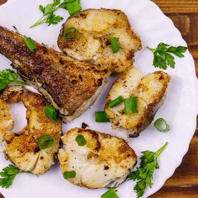 Roasted basa in white plate on a wooden table