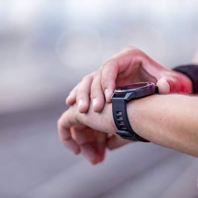 runner outside looking at heart rate monitor smartwatch