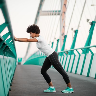 Athletic, young woman exercising on city bridge