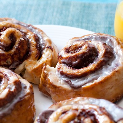 Cinnamon buns and orange juice on a blue background depicting carb and sugar limit to stay in ketosis