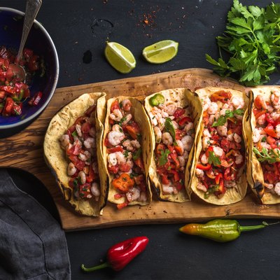 Shrimp tacos with homemade salsa, limes and parsley