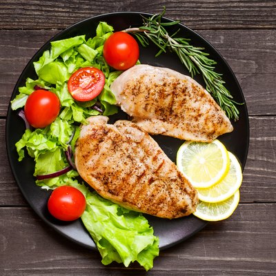 chicken grilled breast fillet with herbs, vegetables and lemon