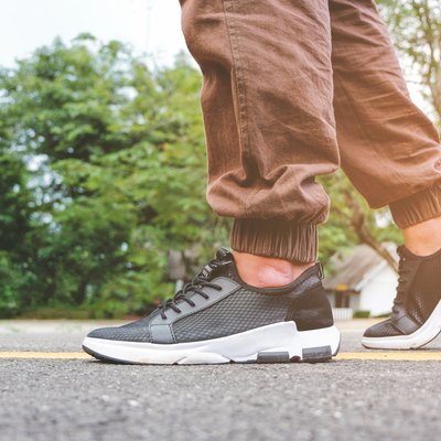 Man walking on a road while wearing walking shoes