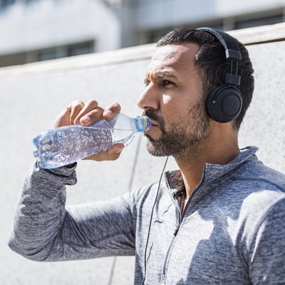 Man drinking from a water bottle that may contain microplastics