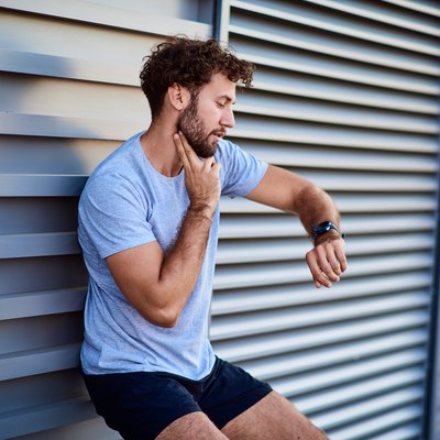 Man taking his pulse to measure heart rate during exercising outside