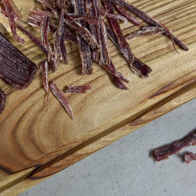 Close up shot of homemade shredded beef jerky on wooden cutting board
