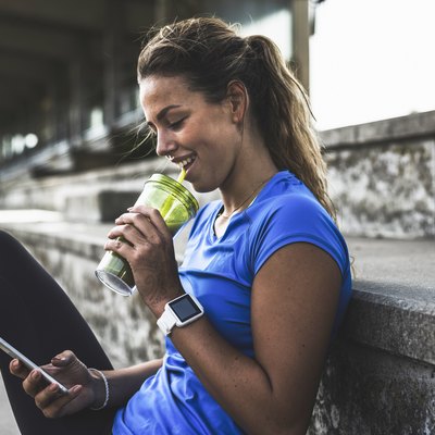 A young woman drinking a smoothie after a workout