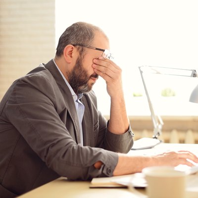 Man working in the office having trouble thinking, possibly due to small vessel brain disease