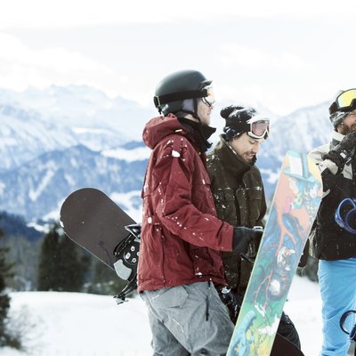 3 friends at the top of a snowy hill, snowboarding and burning calories