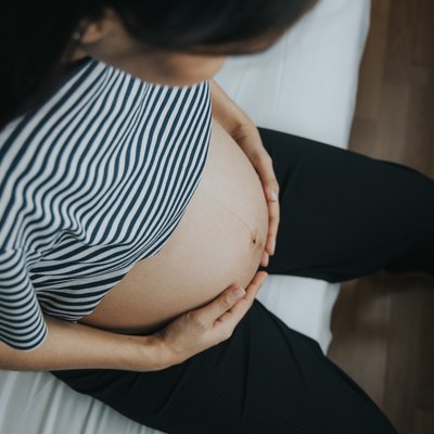 A pregnant woman touching her belly