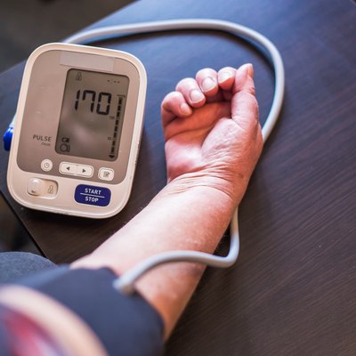 Senior woman measures high blood pressure at home