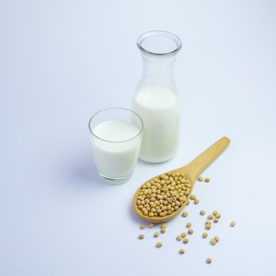 Milk with soy beans on white background